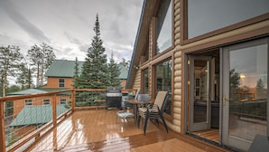A wooden deck with a grill and chairs, overlooking a forested area. - Mountain Cabin w/VIEWS in Brian Head, Utah! Fun to be had Winter, Summer & Fall! (Brian Head)