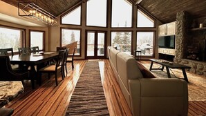 A spacious living area with a high ceiling, large windows, a stone fireplace, and a dining area with wooden flooring. - Mountain Cabin w/VIEWS in Brian Head, Utah! Fun to be had Winter, Summer & Fall! (Brian Head)