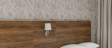 A hotel room with two beds, a wooden headboard, a wall-mounted lamp, and a patterned wallpaper.