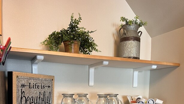 Eine Küchenarbeitsplatte mit Kaffeemaschine, einer Tassenhalterung und einem Schild mit der Aufschrift 'Life is Beautiful'.