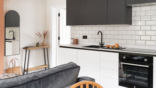 A modern kitchen with white cabinets, a black countertop, and a built-in oven. - Beautiful apartment in central Bath (Bath)