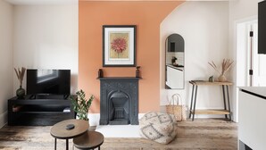 A living room with a fireplace, a television, and a sofa. - Beautiful apartment in central Bath (Bath)