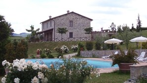 A stone building with a pool and outdoor seating.