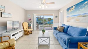 A living room with a TV, sofa, chairs, and a ceiling fan. - Beach Condo |  Pool | 2 Bedrooms | Monthly Rental (Cape Canaveral)