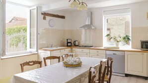 A modern kitchen with a dining area, a coffee maker, and a dishwasher.