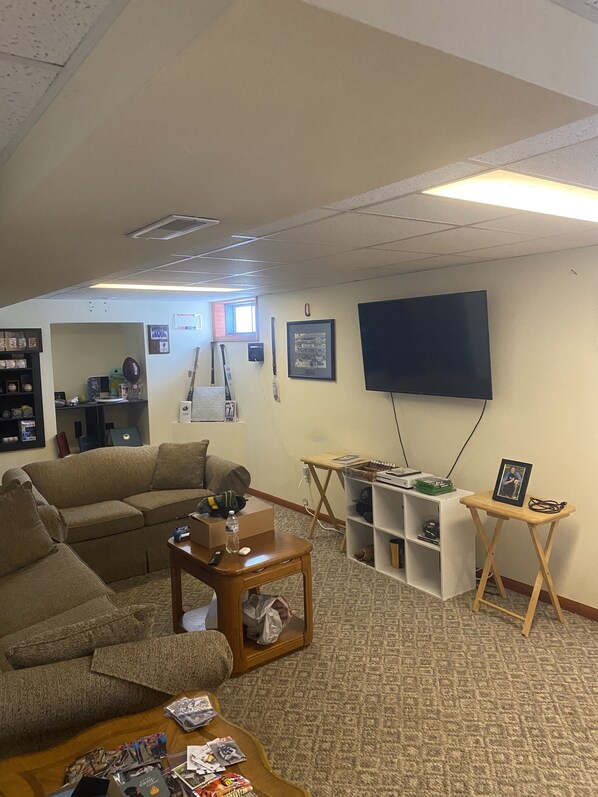 A living room with a sofa, a coffee table, a TV, and a bookshelf.