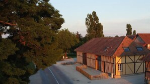 Un bâtiment traditionnel à ossature en bois, doté d’un toit en pente, d’une allée et surplombé d’un ciel dégagé.