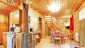 A wooden cabin interior with a kitchen, dining area, and a fireplace. - Le Chant de la Rivière - Chalet 3* pour 8 personnes (Ventron)