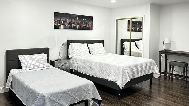 Een moderne hotelkamer met twee eenpersoonsbedden, een bureau en een stoel.
