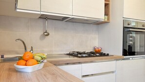 Eine moderne Küche mit Gasherd, Edelstahlgeräten und einer Holzarbeitsplatte.