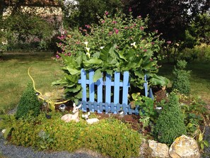 Stroll through a serene garden oasis with a naturalistic pond, fountain, and lush greenery.