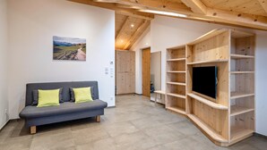 A modern interior with a grey sofa, wooden shelves, and a painting on the wall.