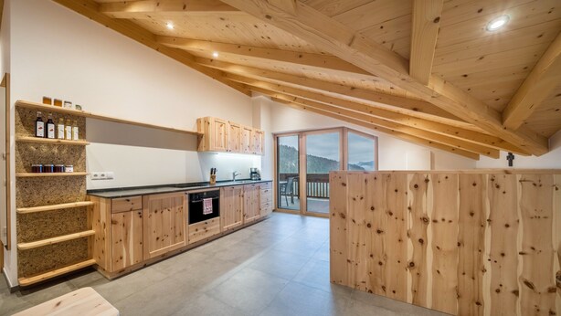 A modern kitchen with wooden cabinets, a granite countertop, and a built-in oven.