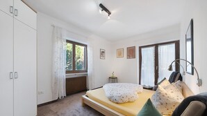 Une chambre avec un lit simple, une fenêtre, un radiateur et une petite table de chevet.