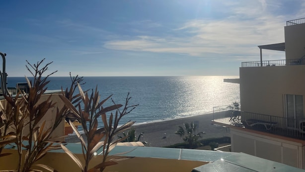 Un balcón con vista al océano y a la playa.