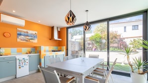 Una cocina moderna con comedor, ventanas amplias y vistas al exterior.