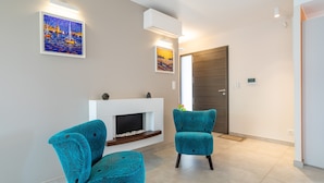 Una sala de estar moderna con dos sillones azul turquesa, una chimenea y dos obras de arte colgadas en la pared.