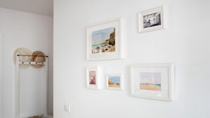 A room with a bed, a bedside table, and a wall with framed pictures. - Family Only Holiday Apartment "Manuela" with Sea View, Shared Terrace & Wi-Fi (CONIL DE LA FRONTERA)