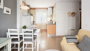 A modern apartment with a dining area, kitchen, and living room. - Family Only Holiday Apartment "Manuela" with Sea View, Shared Terrace & Wi-Fi (CONIL DE LA FRONTERA)