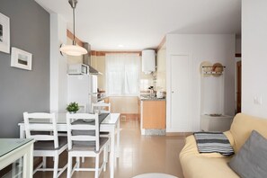 Un appartement moderne comprenant un coin repas, une cuisine et un salon.
