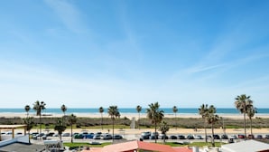 A beach view with palm trees, a parking lot, and a clear sky. - Family Only Holiday Apartment "Manuela" with Sea View, Shared Terrace & Wi-Fi (CONIL DE LA FRONTERA)