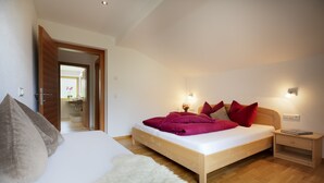 Une chambre avec un lit, une table de chevet, un tapis moelleux et un plancher en bois.