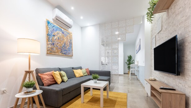 A modern living room with a sofa, a coffee table, a lamp, and a TV. - Apartment 'Casa Carmen' with Shared Pool, Wi-Fi and Air Conditioning (Fuengirola)