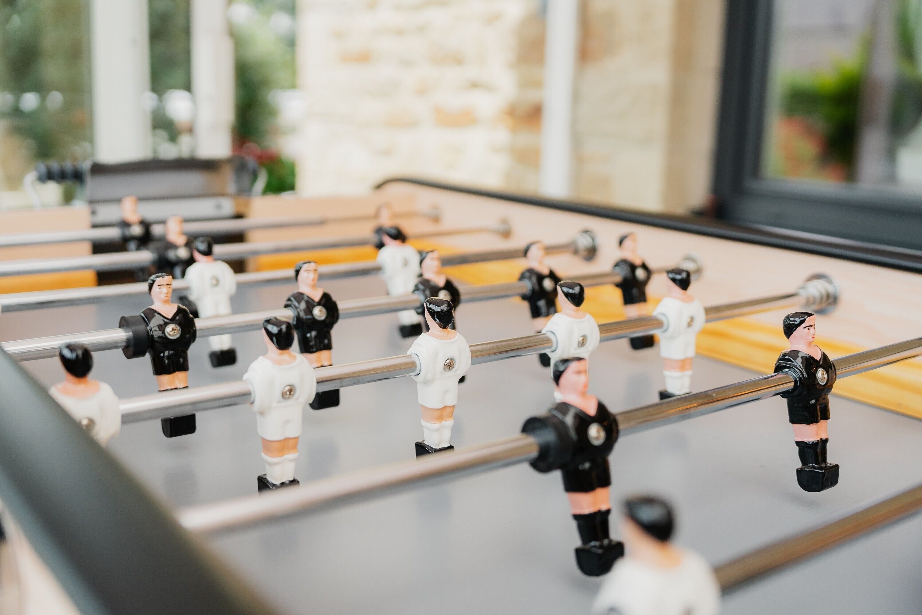 A foosball table with figures in black and white uniforms.
