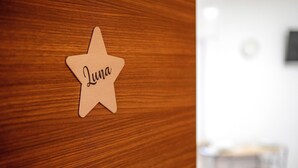 Ein sternförmiges Holzobjekt mit dem Namen 'Luna' auf einer Holzbodenfläche.