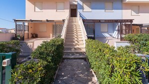 Un edificio de dos pisos con una escalera central que conduce a la entrada.