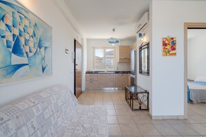 A modern kitchen with wooden cabinets, a dining table, and a large abstract painting on the wall. - Holiday Apartment "Giulietta" with Sea View, Balcony & Wi-Fi (San Lorenzo)