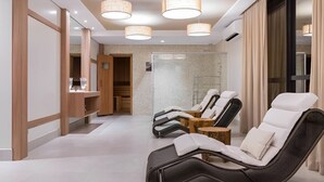 Une salle de spa équipée de trois fauteuils inclinables, d’un meuble en bois et d’une cabine de douche en verre.