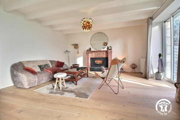 A living room with a sofa, coffee table, and a fireplace.