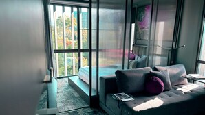 Un dormitorio moderno con un ventanal grande, un sofá y una cama.