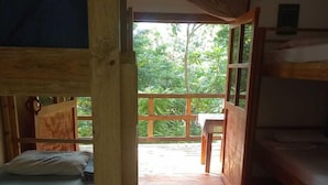 Una habitación de madera con literas y una mesa.