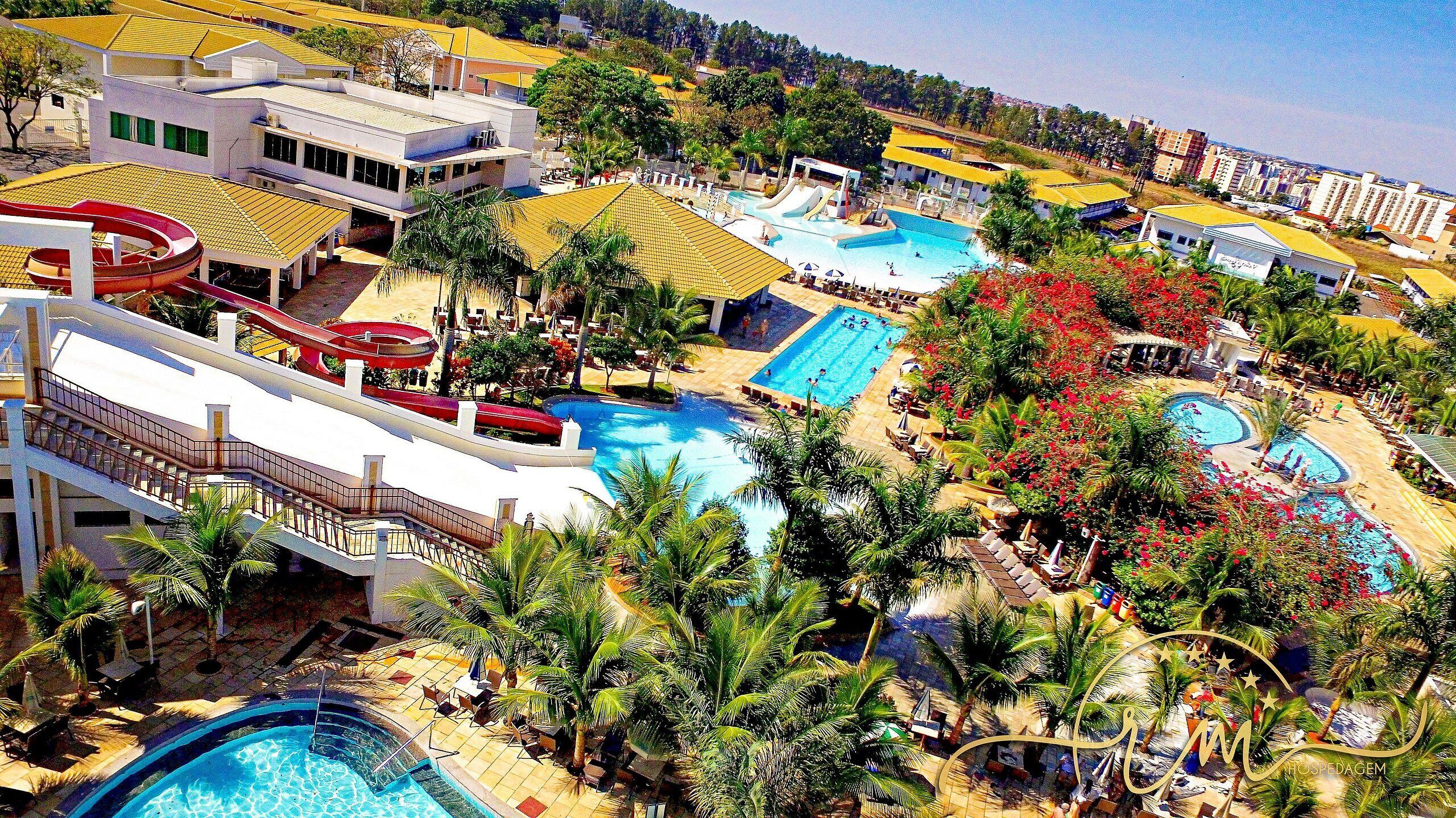 A resort with multiple swimming pools, water slides, and palm trees.