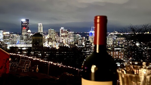 A candle, a wine bottle, and a glass on a table with a cityscape view in the background. - Hidden Pearl - City Skyline View - Free Hot Spa (Pittsburgh)