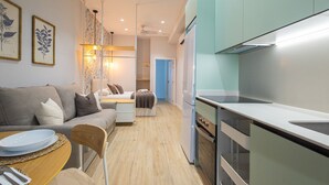A modern kitchen with a built-in oven and a dining area with a table and chairs. - Olive Loft I | AC and WIFI | 10 min City Center (Valencia)
