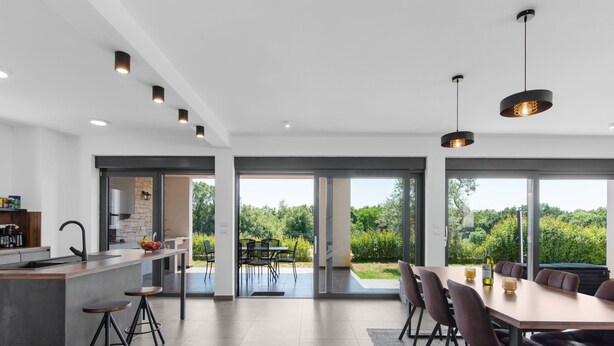 Una cocina moderna con una isla grande, un comedor con vistas y un patio espacioso.