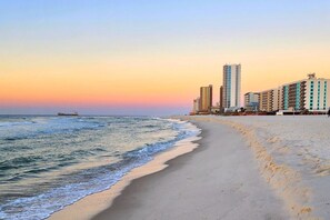 Una playa con una hilera de edificios altos al fondo.