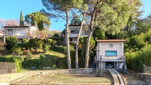 Una villa en una ladera con piscina privada, escalones de piedra y abundante vegetación.