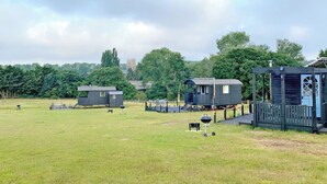 Ein Campingplatz mit mehreren kleinen Hütten, einem Grillbereich und einem Pavillon.