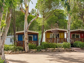 Two cabins with numbers 351 and 352, surrounded by trees and a gravel path. - Lovely apartment in villa for 4 people with hot tub, A/C, WIFI, TV, terrace and pets allowed (Arzachena)