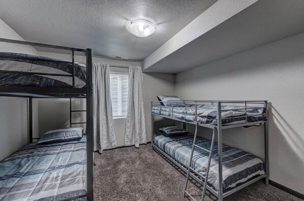 A dormitory room with bunk beds, a window with curtains, and a ceiling light. - Mini-Rushmore, Lots of Street Parking! (Rapid City)