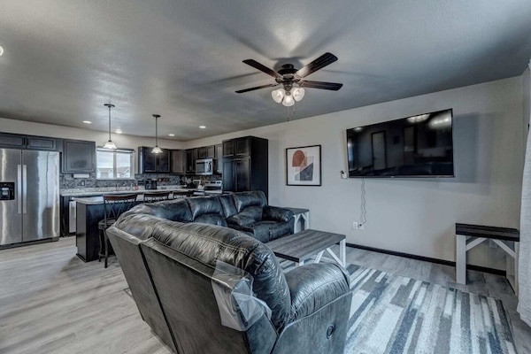 Upper level living room and kitchen, 65" HD Smart TV with comfortable sectional seating with two recliners