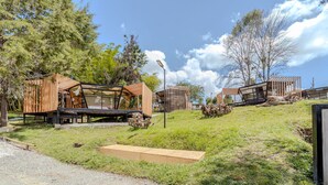 Una estructura moderna al aire libre con cerramiento de vidrio, vigas de madera y estructura metálica.
