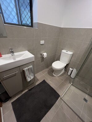 Ein Badezimmer mit Waschbecken, Toilette und Dusche.