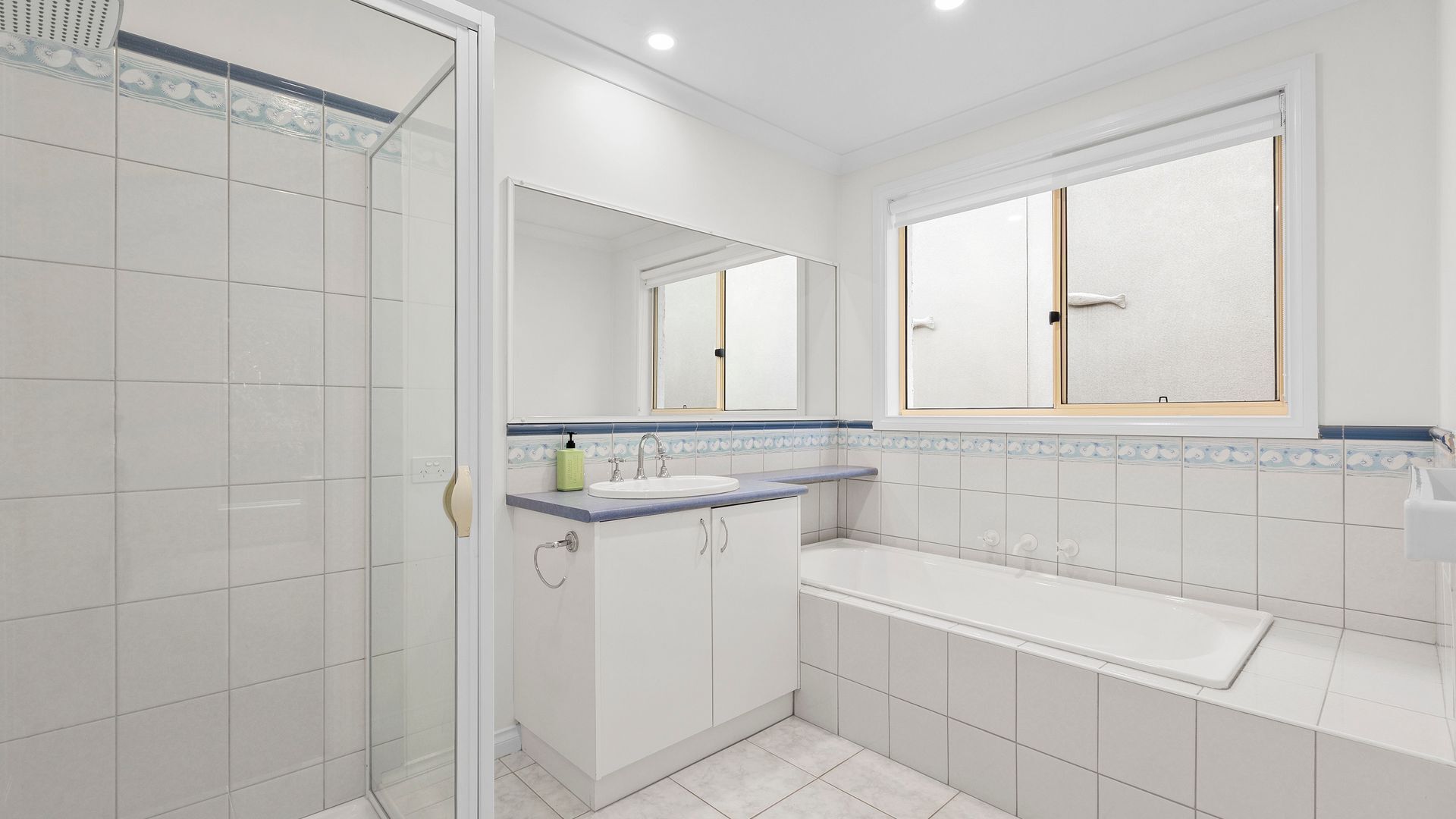 A modern bathroom with a shower, sink, and bathtub.