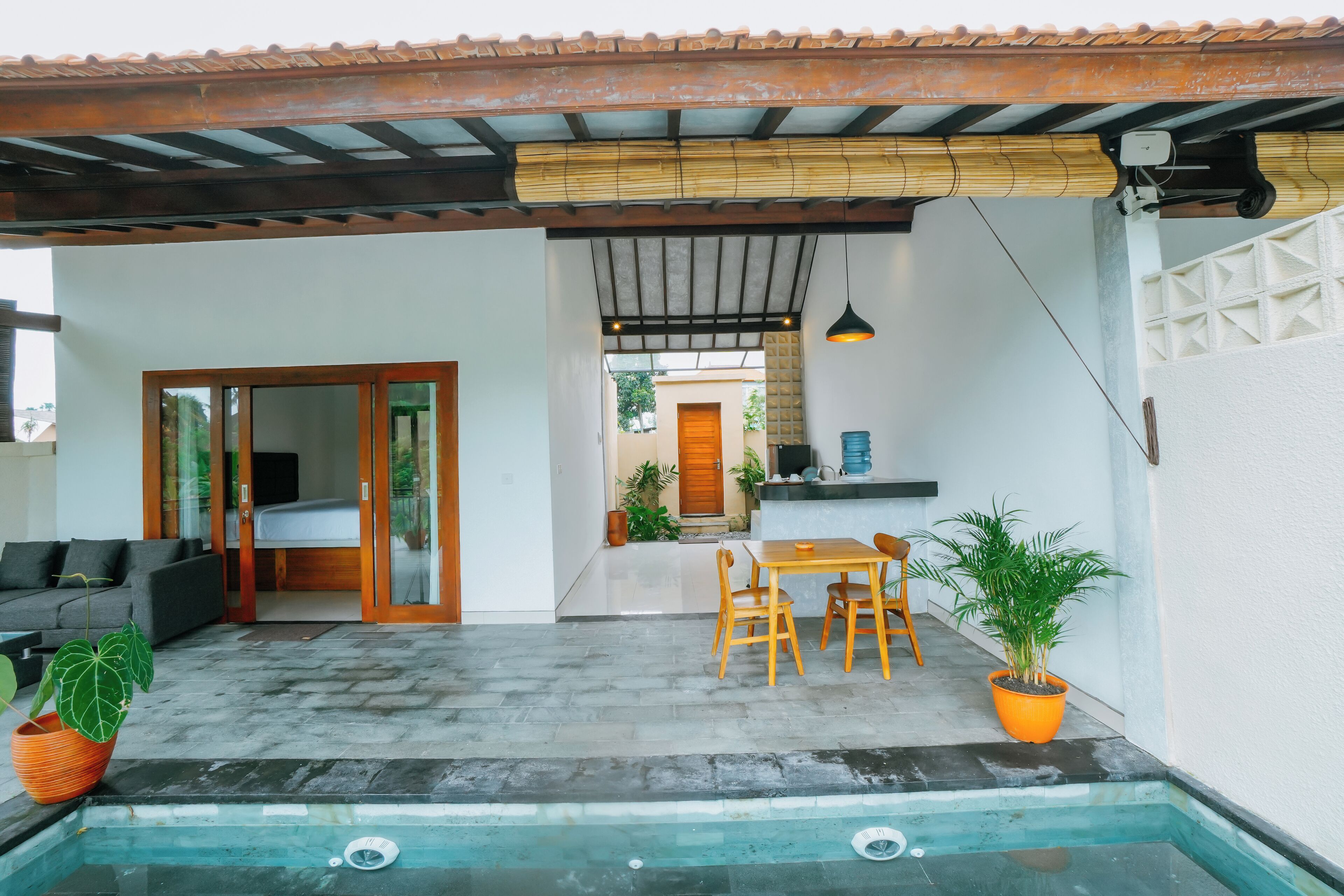 Un espacio exterior moderno con piscina, asientos y una mesa de comedor.
