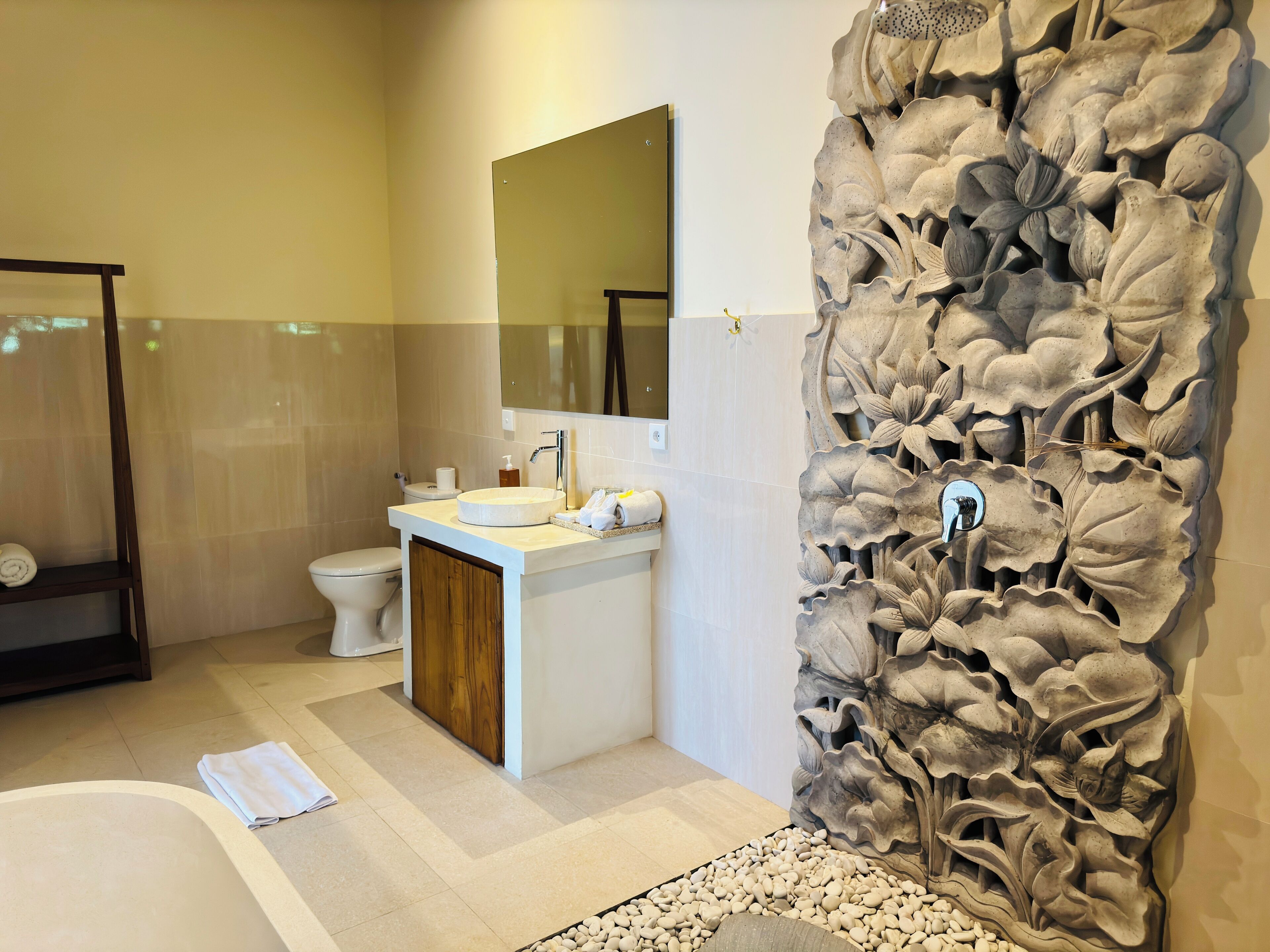 A modern bathroom with a large bathtub, a sink, and a toilet.